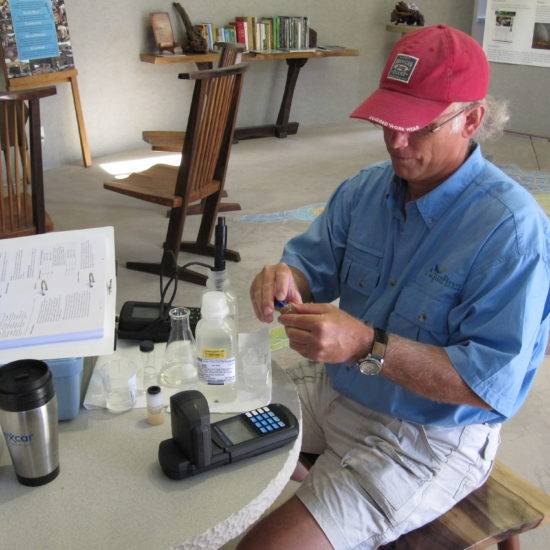 A man is testing the quality of creek water at a scientific station.
