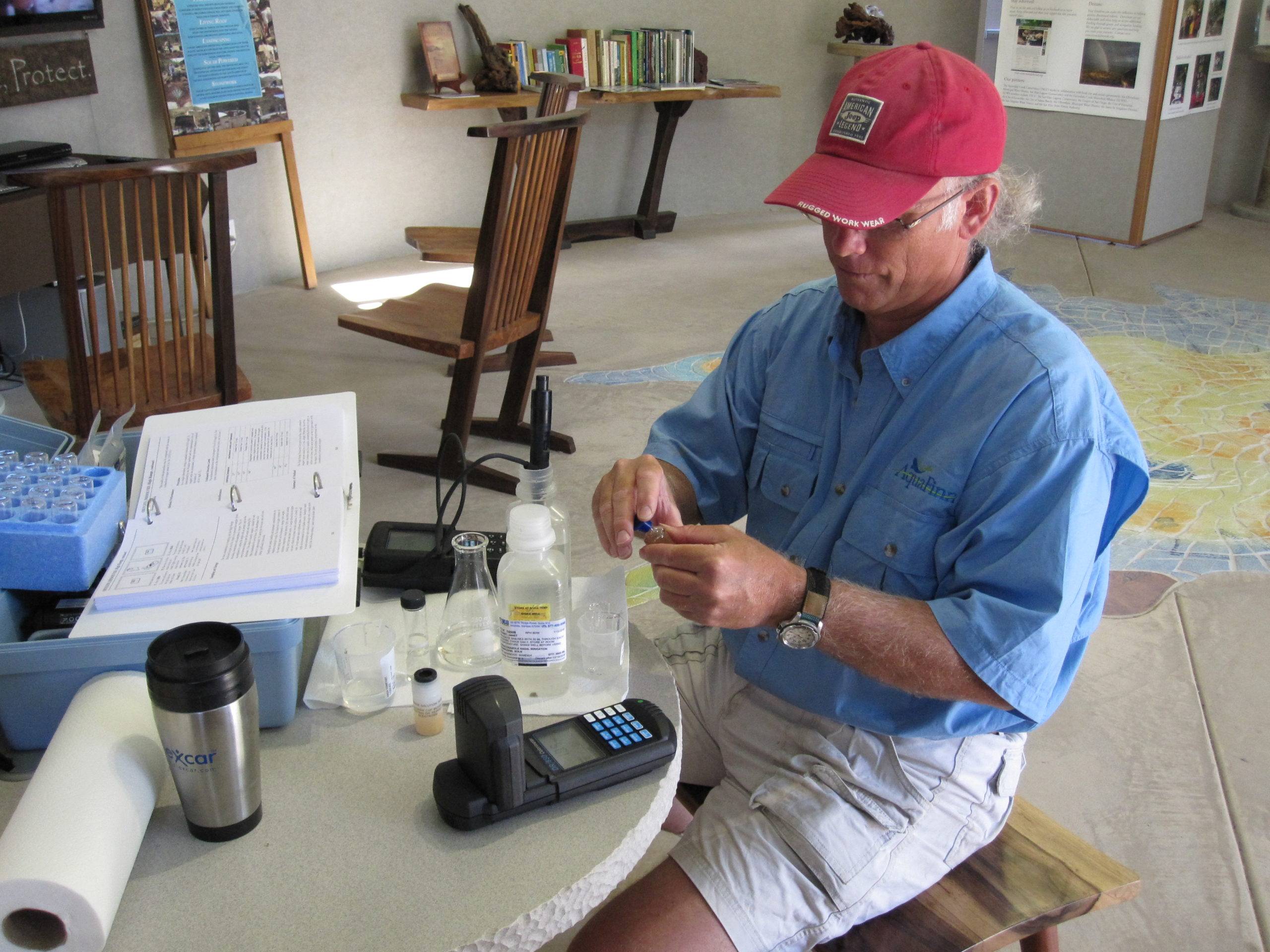 A man is testing the quality of creek water at a scientific station.