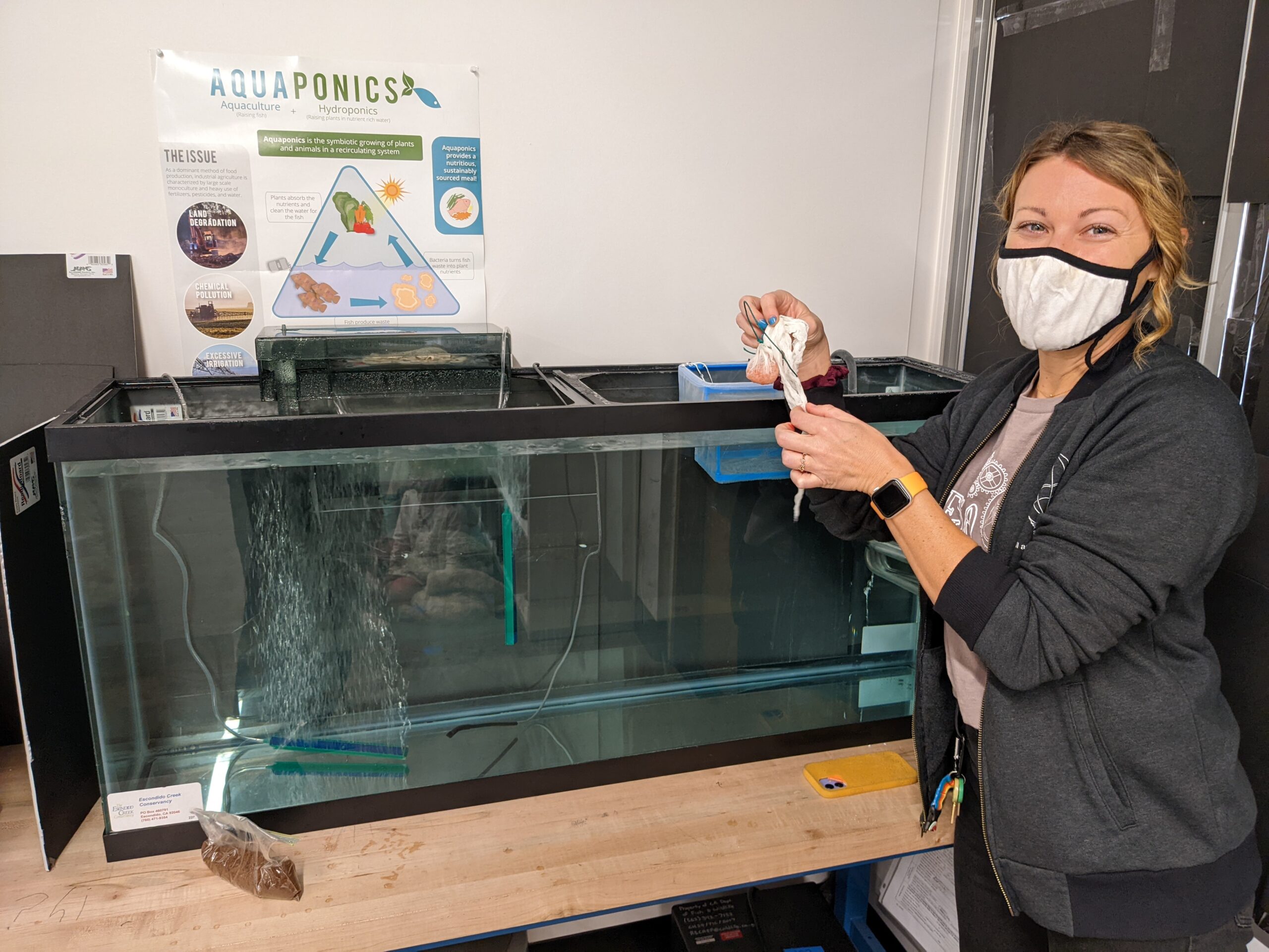 High Tech Elementary teacher Stephanie Lance, a first-time participant in the program, prepares to place a bundle of trout eggs in her aquarium.
