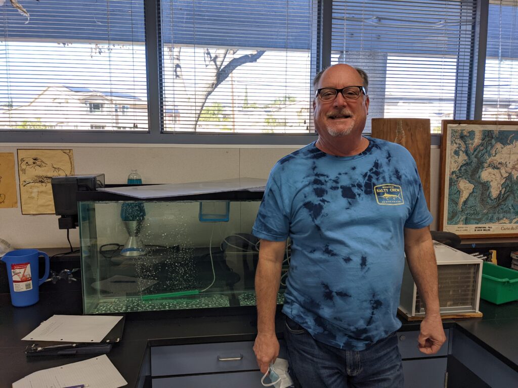 Rincon Middle School 8th grade teacher Bruce Peterson, in front of his aquarium. The Conservancy provisions the equipment, offers technical support, and provides lessons as part of the program.