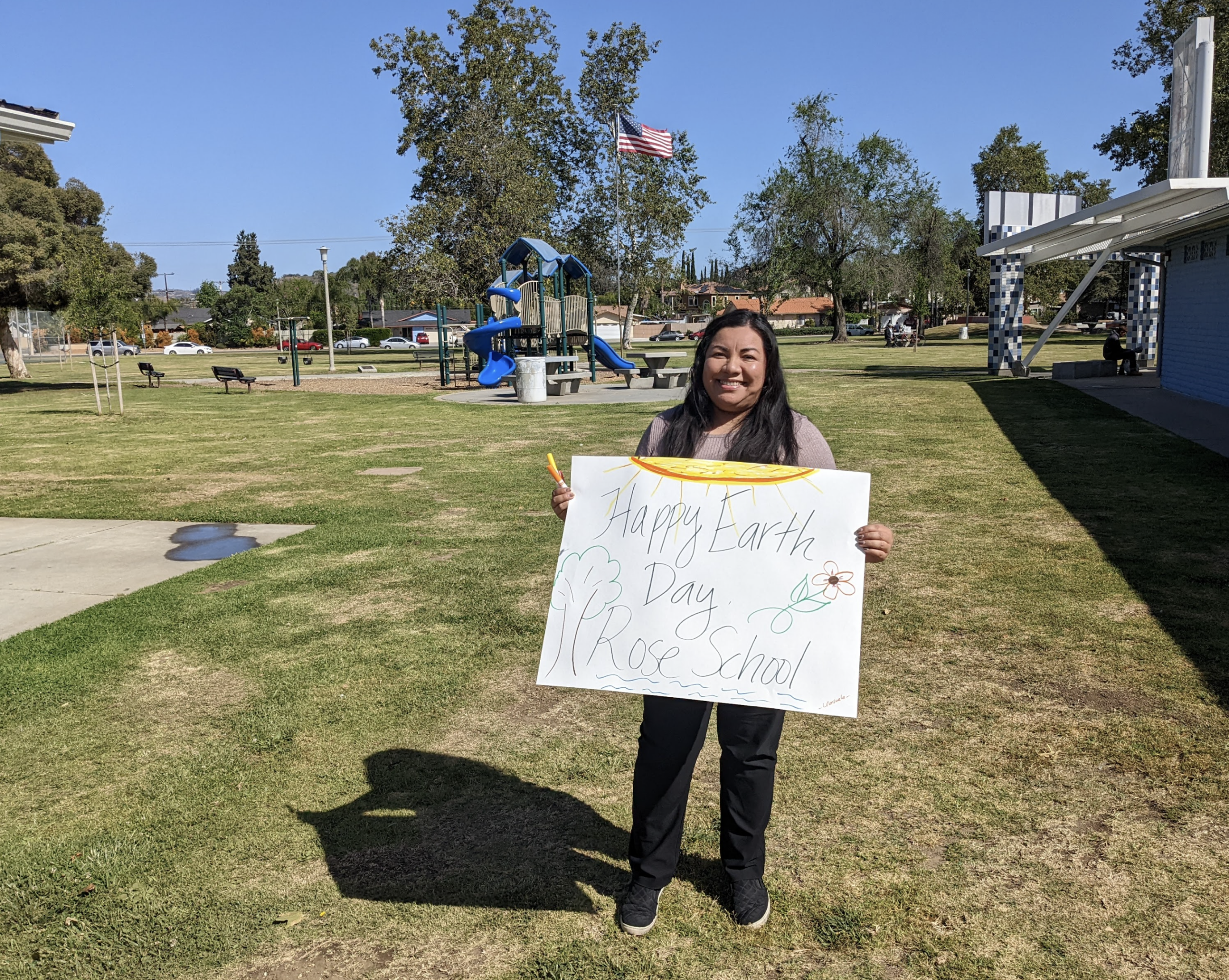 A women holds an Earth Day sign in the park