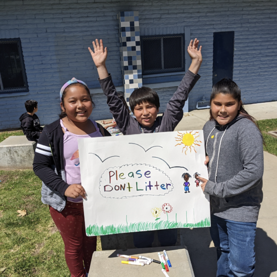 Students display the sign they made for Earth Day.