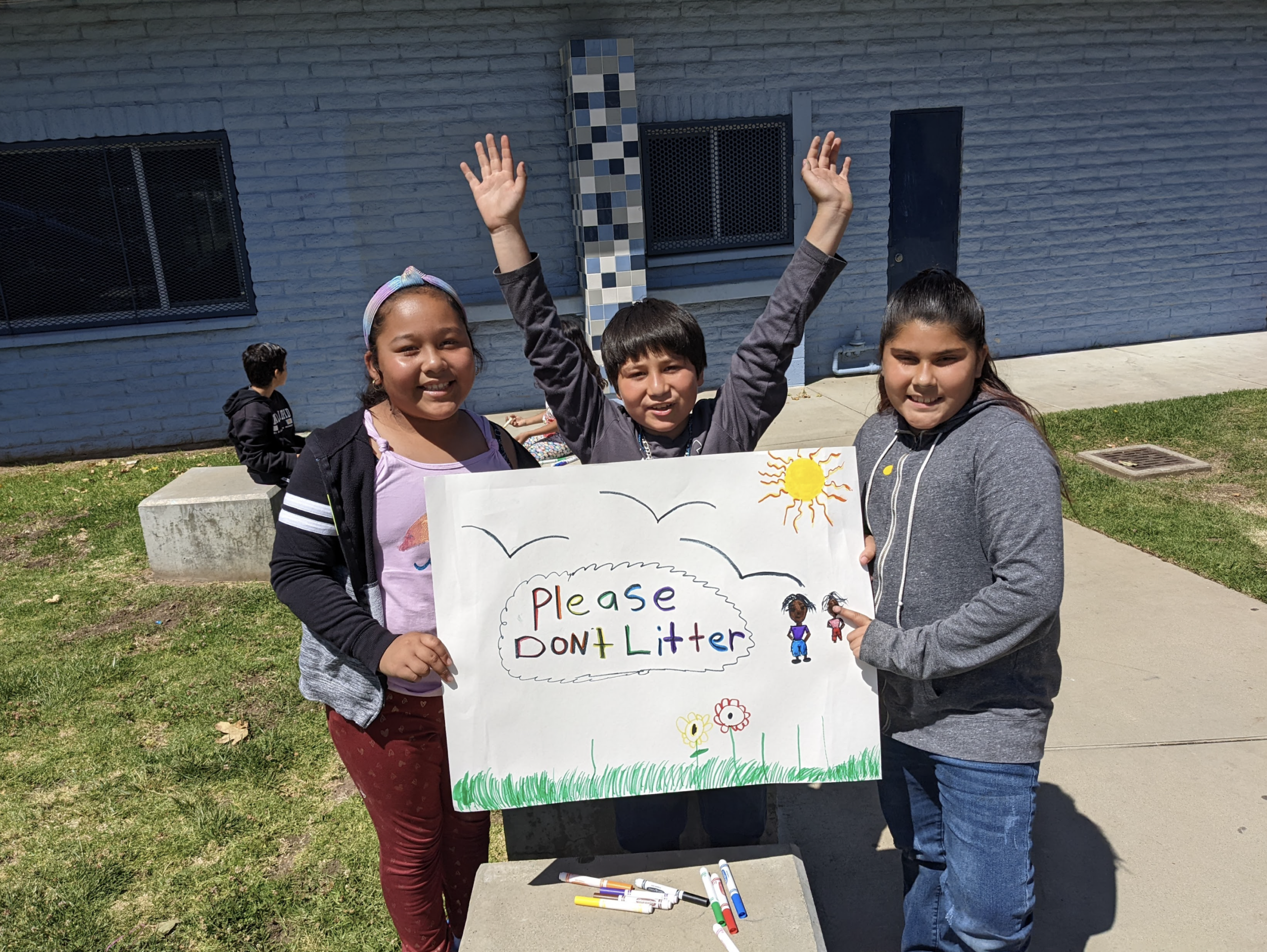 Students display the sign they made for Earth Day.